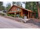 Well-maintained log cabin with a green roof, surrounded by trees and situated on a hill at 401 Alpine Way, Las Vegas, NV 89124