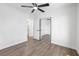 Bright bedroom featuring wood floors, a ceiling fan, and a large mirrored closet at 404 Vassar Ln, Las Vegas, NV 89107