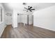 Bright bedroom featuring wood floors, a ceiling fan, and a large mirrored closet with an ensuite bathroom at 404 Vassar Ln, Las Vegas, NV 89107