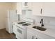 Galley-style kitchen boasts modern white cabinets, white appliances, and updated countertops at 404 Vassar Ln, Las Vegas, NV 89107