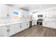 Bright kitchen featuring white cabinets, stone countertops, stainless steel appliances, and wood flooring at 404 Vassar Ln, Las Vegas, NV 89107