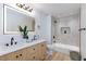 Double sink vanity with light wood cabinets next to the shower and toilet at 4176 Demoline Cir, Las Vegas, NV 89141