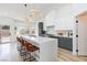 Bright kitchen with waterfall island, stylish pendant lighting, stainless appliances and breakfast bar seating at 4176 Demoline Cir, Las Vegas, NV 89141