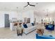 Open-concept living room with kitchen, island seating, and stylish pendant lighting at 4176 Demoline Cir, Las Vegas, NV 89141