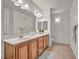 Bathroom featuring double sinks, wood cabinets, a large mirror, and great lighting at 50 Aura De Blanco St # 2104, Henderson, NV 89074