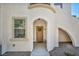 Inviting front entrance with arched entryway and warm wood front door at 50 Aura De Blanco St # 2104, Henderson, NV 89074