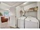 Convenient laundry room with side-by-side washer and dryer and storage shelves at 50 Aura De Blanco St # 2104, Henderson, NV 89074