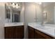 Bathroom with double sink vanity featuring wood cabinets, bright lighting, and large mirrors above each sink at 5016 Wayfaring Tree Ave, Las Vegas, NV 89131