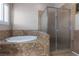 Bathroom showcasing a tiled tub with steps and a glass-enclosed shower with neutral accents at 5016 Wayfaring Tree Ave, Las Vegas, NV 89131
