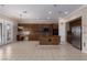 Open kitchen and dining area with granite counters, island, stainless fridge, and tile flooring at 5016 Wayfaring Tree Ave, Las Vegas, NV 89131