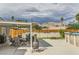 View of backyard with a table and chairs, along with a metal fire pit, fence, and pool in the distance at 5217 Champions Ave, Las Vegas, NV 89142