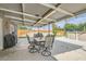 Covered patio with dining set, barbecue grill, and view of the pool, great for outdoor dining and relaxation at 5217 Champions Ave, Las Vegas, NV 89142