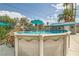 Above-ground pool with wooden steps, a seating area, a nearby shaded bar area, and mature landscaping at 5217 Champions Ave, Las Vegas, NV 89142