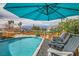 Relaxing pool area with lounge chairs, covered patio, and privacy fence at 5217 Champions Ave, Las Vegas, NV 89142