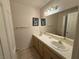 Bright bathroom featuring a double sink vanity, framed mirrors, and tiled countertops at 5424 Comchec Way # 101, Las Vegas, NV 89108