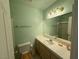 Well-lit bathroom featuring a toilet, sink with a vanity, and tile countertops at 5424 Comchec Way # 101, Las Vegas, NV 89108