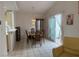 Open concept dining room with tiled floors, glass doors to the patio, and modern lighting at 5424 Comchec Way # 101, Las Vegas, NV 89108