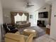 Cozy living room with comfortable seating, ceiling fan, and large windows with draping curtains at 5424 Comchec Way # 101, Las Vegas, NV 89108