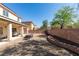 Wide backyard with a covered patio, gravel, and an appealing brick-lined garden at 6052 Puesta Del Sol St, North Las Vegas, NV 89081