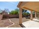 Inviting covered patio overlooking a gravel backyard with a charming brick-lined border at 6052 Puesta Del Sol St, North Las Vegas, NV 89081