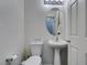 Compact half bathroom features a pedestal sink, toilet, and neutral decor at 6052 Puesta Del Sol St, North Las Vegas, NV 89081