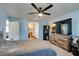 Comfortable bedroom with an open doorway to the en-suite bathroom and large screen TV at 6052 Puesta Del Sol St, North Las Vegas, NV 89081