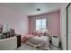 Bedroom painted pink, with a comfortable bed and a window providing natural light at 6052 Puesta Del Sol St, North Las Vegas, NV 89081