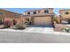 Charming two-story home with a tile roof, stone accents, and a well-manicured front yard at 6052 Puesta Del Sol St, North Las Vegas, NV 89081