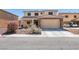 Charming two-story home with a tile roof, stone accents, and a well-manicured front yard at 6052 Puesta Del Sol St, North Las Vegas, NV 89081