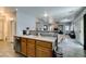 Open kitchen with wood cabinets, stainless steel dishwasher, and gray wood-look flooring at 6052 Puesta Del Sol St, North Las Vegas, NV 89081