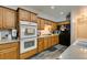 Bright kitchen with wood cabinets, double oven, and sleek gray wood-look floors at 6052 Puesta Del Sol St, North Las Vegas, NV 89081