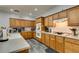 Well-lit kitchen with wood cabinets, stainless steel appliances, and gray wood-look flooring at 6052 Puesta Del Sol St, North Las Vegas, NV 89081