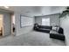 Comfortable living room with a plush black sectional sofa, home theater and neutral decor at 6052 Puesta Del Sol St, North Las Vegas, NV 89081