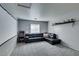 Cozy living room featuring a plush black sectional sofa, arcade game, and neutral decor at 6052 Puesta Del Sol St, North Las Vegas, NV 89081