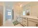 Bright bathroom featuring double sinks, a large mirror, and tiled floors at 6607 Summershade St, North Las Vegas, NV 89086