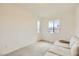 Neutral room with carpeted floors, a comfortable sofa, and natural light from two windows at 6607 Summershade St, North Las Vegas, NV 89086