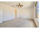 Spacious bedroom with carpeted floors, ceiling fan, large window, and access to the rest of the home at 6607 Summershade St, North Las Vegas, NV 89086