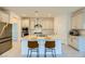 Bright kitchen with island seating, stainless steel appliances, and neutral cabinets, offering a functional design at 6607 Summershade St, North Las Vegas, NV 89086