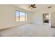 Large main bedroom with carpeted floors, ceiling fan, large window, and access to the rest of the home at 6607 Summershade St, North Las Vegas, NV 89086