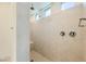 Tiled shower with built-in seat, rainfall shower head, and window at 6607 Summershade St, North Las Vegas, NV 89086