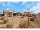 Expansive backyard with desert landscaping, a fire pit, and multiple seating areas for outdoor enjoyment at 7115 Calvert Cliffs St, North Las Vegas, NV 89084