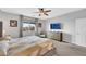 Airy main bedroom with a ceiling fan, carpet flooring, stylish furniture, and a large window at 7115 Calvert Cliffs St, North Las Vegas, NV 89084