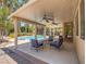 Covered patio with comfortable seating area overlooking the backyard pool and lush greenery at 8106 Eagle Clan Ct, Las Vegas, NV 89131
