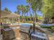 Outdoor kitchen area with a grill, sink, and beautiful landscaping overlooking the backyard pool at 8106 Eagle Clan Ct, Las Vegas, NV 89131