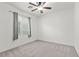 Bedroom with modern ceiling fan, soft carpet, and large window with natural light at 8220 Chimney Bluffs St, North Las Vegas, NV 89085