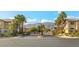 Inviting gated community entrance featuring lush landscaping, palm trees, and mountain views beyond at 8220 Chimney Bluffs St, North Las Vegas, NV 89085