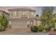 Charming two-story home featuring a manicured front yard and an attached two-car garage at 8220 Chimney Bluffs St, North Las Vegas, NV 89085
