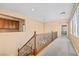Bright hallway with carpet, decorative railing and view into other rooms at 8220 Chimney Bluffs St, North Las Vegas, NV 89085