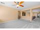Spacious living room with neutral walls, plush carpets, and modern ceiling fan at 8220 Chimney Bluffs St, North Las Vegas, NV 89085