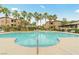 Community pool surrounded by palm trees and lounge chairs at 8985 S Durango Dr # 1177, Las Vegas, NV 89113